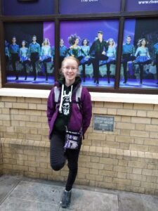 Lily May in front of River Dance poster
